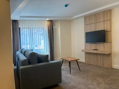 a living room with a couch and a flat screen tv at Roys Hotel & Suites in Istanbul