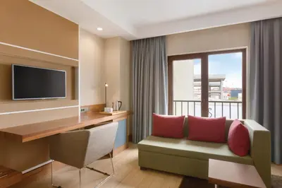 a hotel room with a desk and a couch at Ramada by Wyndham Istanbul Florya in Istanbul