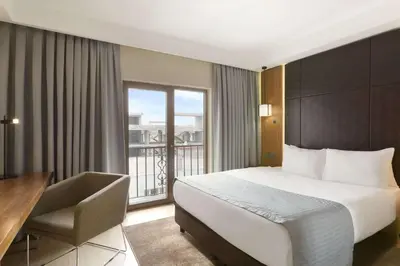a hotel room with a bed and a desk and a window at Ramada by Wyndham Istanbul Florya in Istanbul