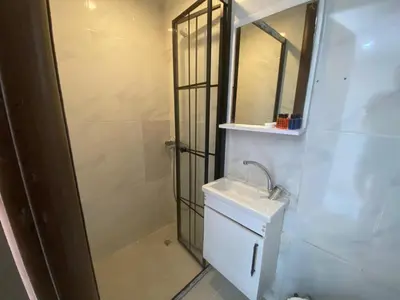 a white bathroom with a sink and a shower at The Red Tent Loft Suites in Istanbul