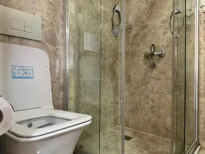 a bathroom with a toilet and a glass shower at Hotel Visa in Istanbul