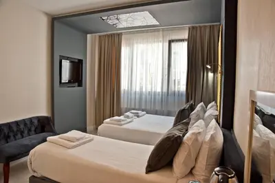 a hotel room with two beds and a mirror at Yakut Hotel in Istanbul