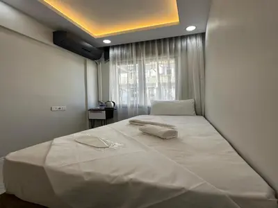 a large white bed in a room with a window at Asıl Kosova Hotel in Istanbul