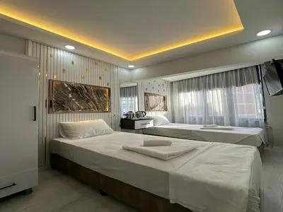 a hotel room with two beds and a television at Asıl Kosova Hotel in Istanbul