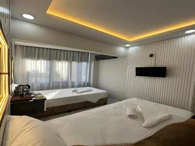 a bedroom with two beds and a window at Asıl Kosova Hotel in Istanbul