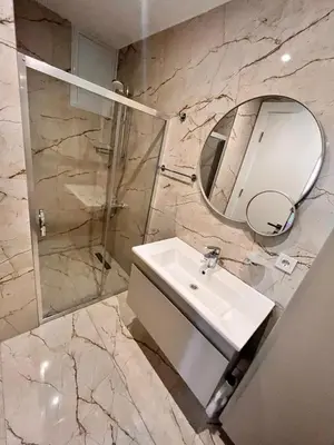 a bathroom with a sink and a mirror and a shower at Sense Suite Residence-KAPALI in Istanbul