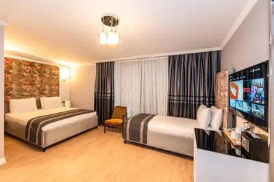 a hotel room with two beds and a flat screen tv at The Now Hotel in Istanbul