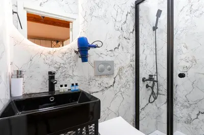 a bathroom with a black sink and a shower at The Astra Hotel in Istanbul