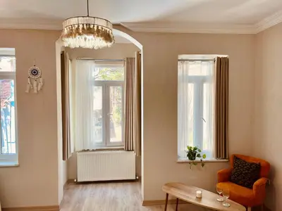 a living room with a chair and a table and windows at BOHO HOUSE Istanbul in Istanbul