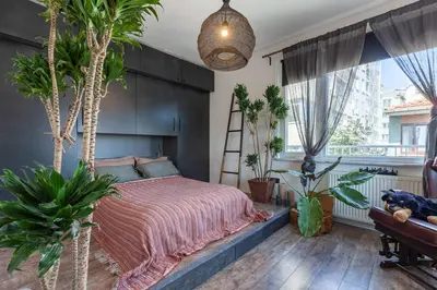 a bedroom with a bed and a bunch of plants at Panoramic Sea View Loft with Terrace BBQ in Istanbul
