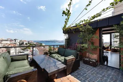 a balcony with a couch and a table on a building at Panoramic Sea View Loft with Terrace BBQ in Istanbul