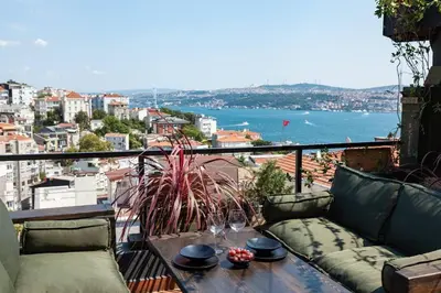 a balcony with a couch and a view of the water at Panoramic Sea View Loft with Terrace BBQ in Istanbul