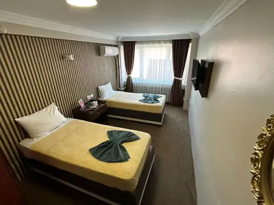 a hotel room with two beds and a television at Hotel Metropol 1 in Istanbul