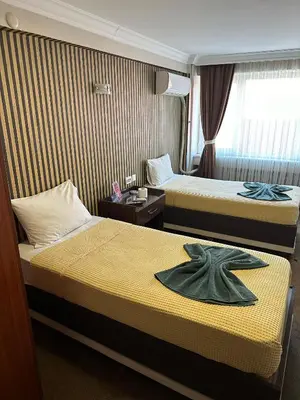 two beds in a hotel room with a robe on them at Hotel Metropol 1 in Istanbul