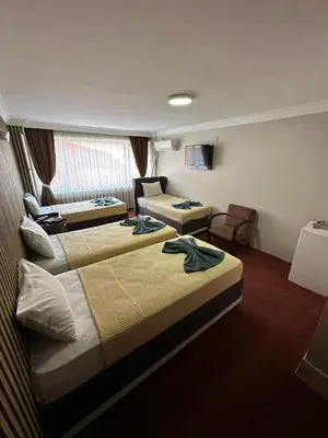 a hotel room with two beds and a couch at Hotel Metropol 1 in Istanbul