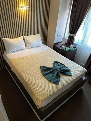 a bedroom with a bed with a bow tie on it at Hotel Metropol 1 in Istanbul