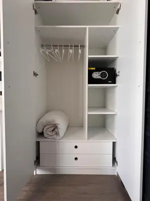 a walk in closet with white shelves and a microwave at Galata studio in Istanbul