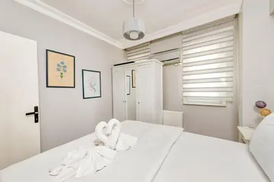 a white bedroom with a bed with a towel on it at Qbra House in Istanbul