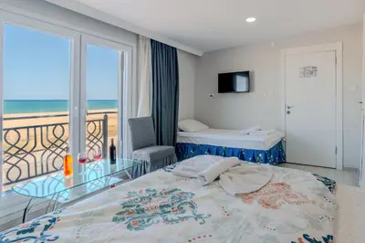 a bedroom with a bed and a balcony with the ocean at İstanbul Airport Black Sea Hotel in Arnavutköy