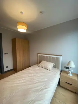 a bedroom with a large white bed and a cabinet at NEW Modern Central 2BR 2BA in Istanbul