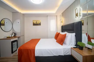 a bedroom with a large bed with orange pillows at Robin Hotel in Istanbul