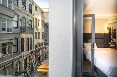 a room with a balcony with a bed and a bed at Robin Hotel in Istanbul