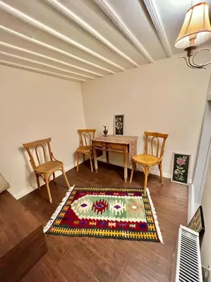 a living room with a table and chairs and a rug at Konak Maksem in Bursa