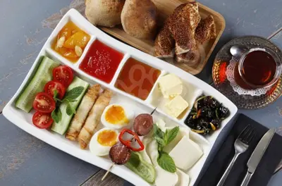 a plate of food with eggs and vegetables and bread at BZN Airport Hotel in Arnavutköy
