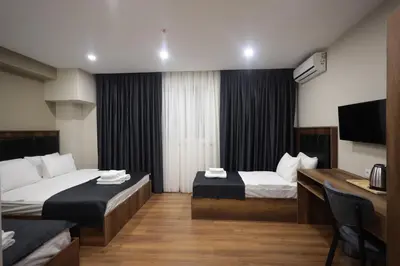 a hotel room with two beds and a flat screen tv at BZN Airport Hotel in Arnavutköy