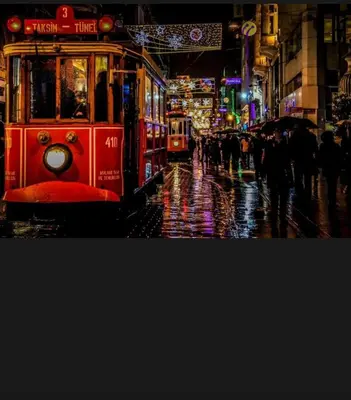 a red trolley car on a city street at night at La Pazza Suites in Istanbul