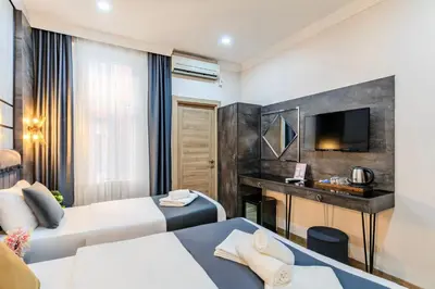 a hotel room with two beds and a television at La Pazza Suites in Istanbul