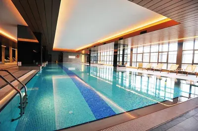 a large swimming pool in a large building at Modern Luxury apt at Sinpas Queen in Istanbul