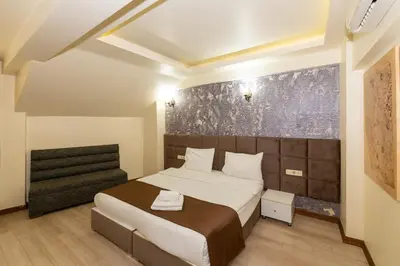 a bedroom with a large bed and a chair at taksim terra suit 2 in Istanbul