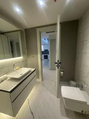 a bathroom with a sink and a toilet and a mirror at Sinpaş Queen Bomonti Residence by Bondy in Istanbul