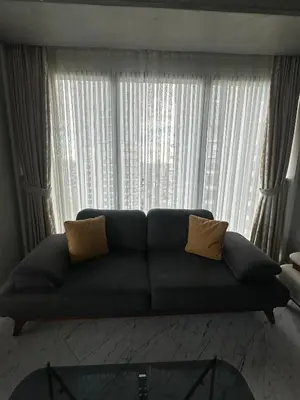 a couch in a living room with a large window at Sinpaş Queen Bomonti Residence by Bondy in Istanbul