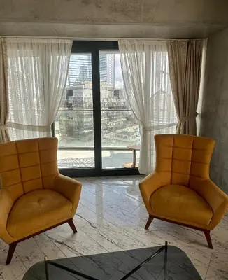 two chairs in a room with a large window at Sinpaş Queen Bomonti Residence by Bondy in Istanbul