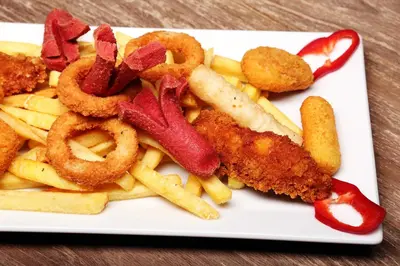 a plate of food with fried onion rings and french fries at Sarissa Hotel in Istanbul