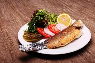a plate of food with fish and vegetables on a table at Sarissa Hotel in Istanbul