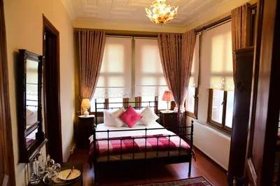 a bedroom with a bed with pink pillows in a window at Ottoman Suites by Sera House in Istanbul
