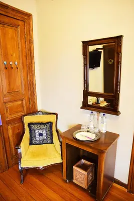 a bathroom with a table and a chair and a mirror at Ottoman Suites by Sera House in Istanbul