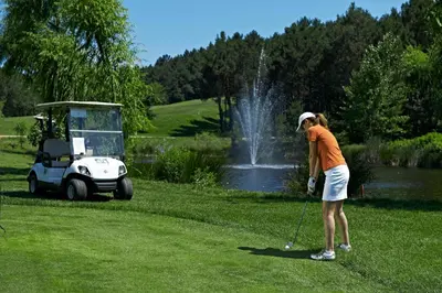 a woman is playing golf in front of a fountain at Kemer Country Hotel İstanbul in Istanbul