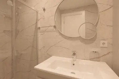 a white bathroom with a sink and a mirror at Sense Suite Residence-15 in Istanbul