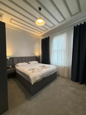 a bedroom with a large bed with blue curtains at Lighthouse in Istanbul