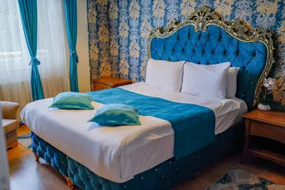a bedroom with a blue bed with two pillows on it at Green Moringa Termal Hotel in Termal