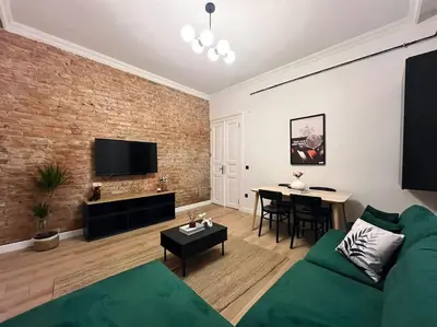 a living room with a green couch and a brick wall at Charming 2BR AC in Center - Santur D1 in Istanbul