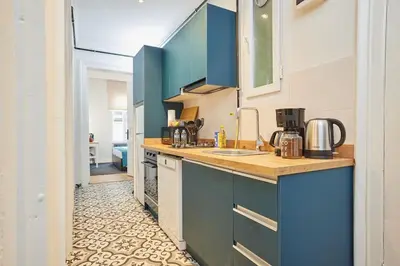 a kitchen with blue cabinets and a tile floor at Charming 3BR 2Bath AC in Center - Santur D8 in Istanbul