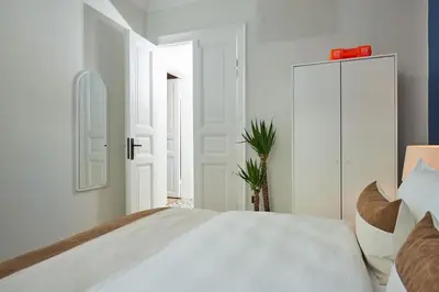 a white bedroom with a large bed and a plant at Spacious 3BR 2Bath AC in Center - Santur D9 in Istanbul