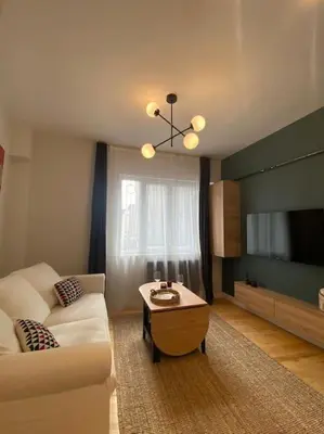 a living room with a couch and a table at Stunning Apartment Near Metro - Değirmen 64 in Istanbul