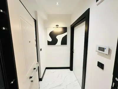 a hallway with white walls and a black door at Rose Point Residence in Istanbul