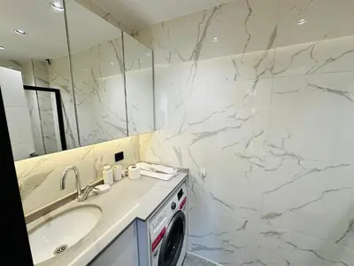 a bathroom with a sink and a washing machine at Rose Point Residence in Istanbul